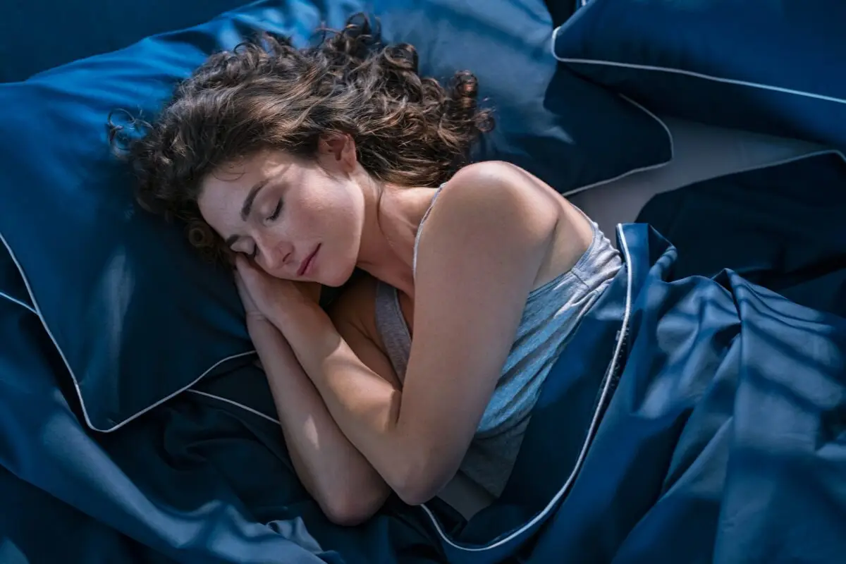 Woman sleeping comfortably in a blue bed