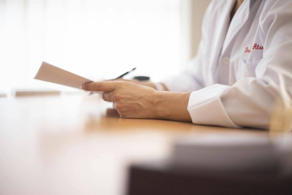 A close-up photo of a doctor holding a medical report. Source - Pexels