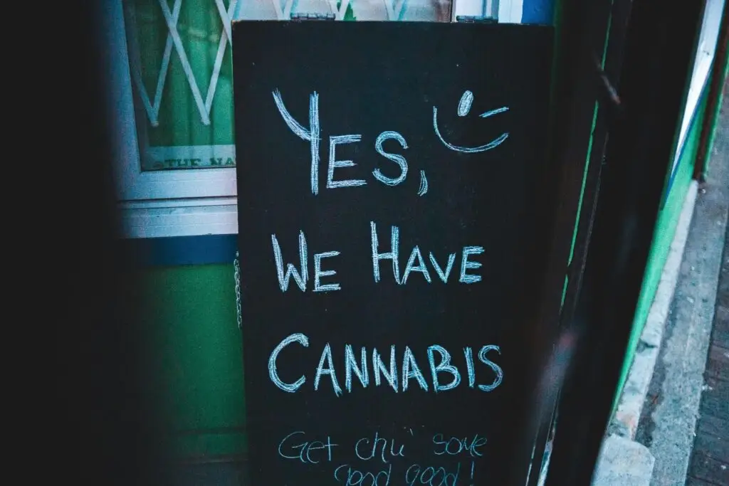 A board with a cannabis advert placed against a wall. Source - Pexels