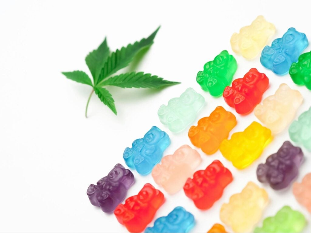 Cannabis leaf next to colorful cannabis gummies. Source - Pexels