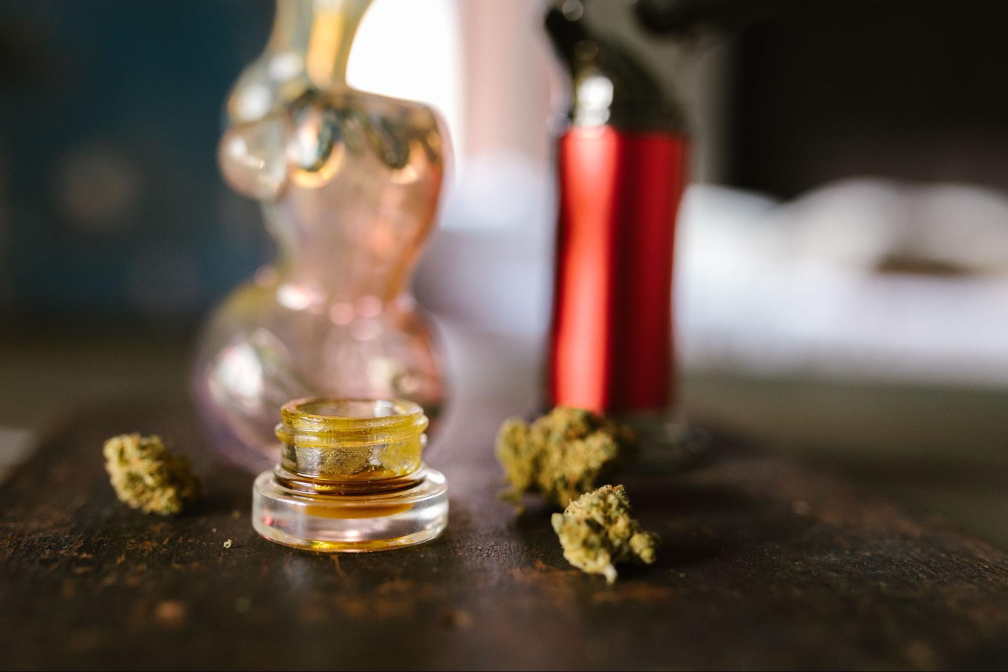 A glass cap with cannabis concentrates with cannabis flower next to it. Source - Pexels